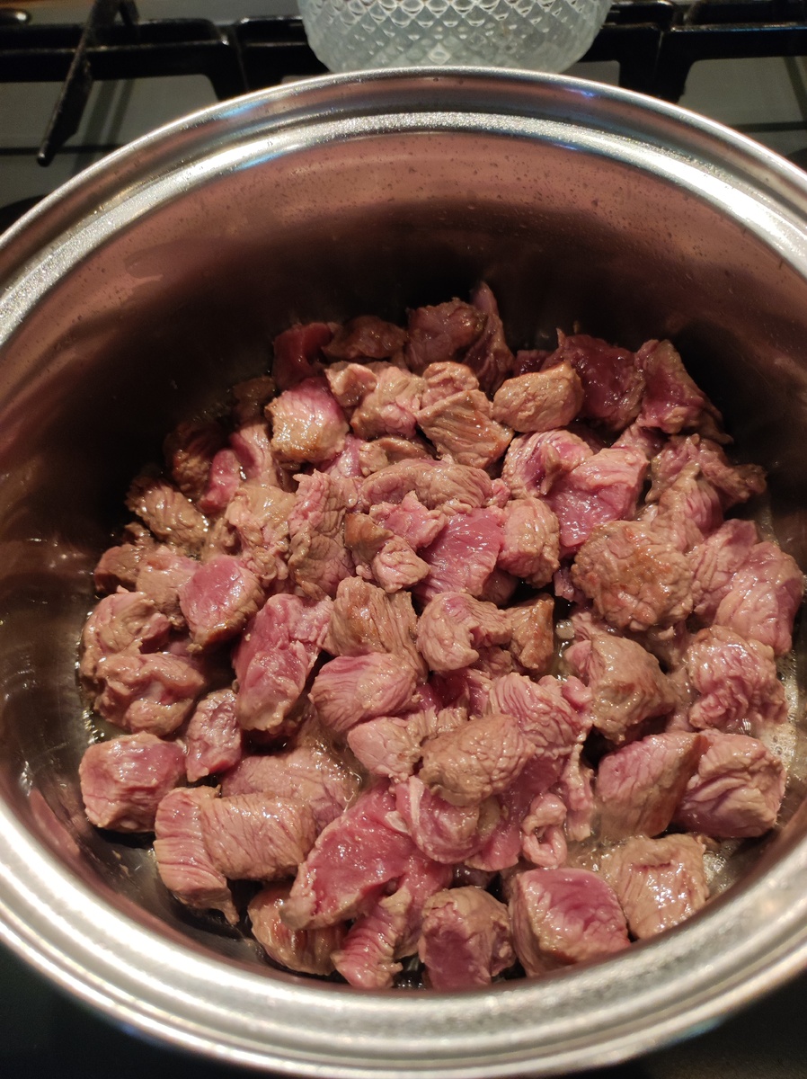 В кастрюлю наливаем 30 гр растительного масла и очень хорошо разогреваем. После этого кладём всё мясо и перемешивая, даём запечататьс сокам. 