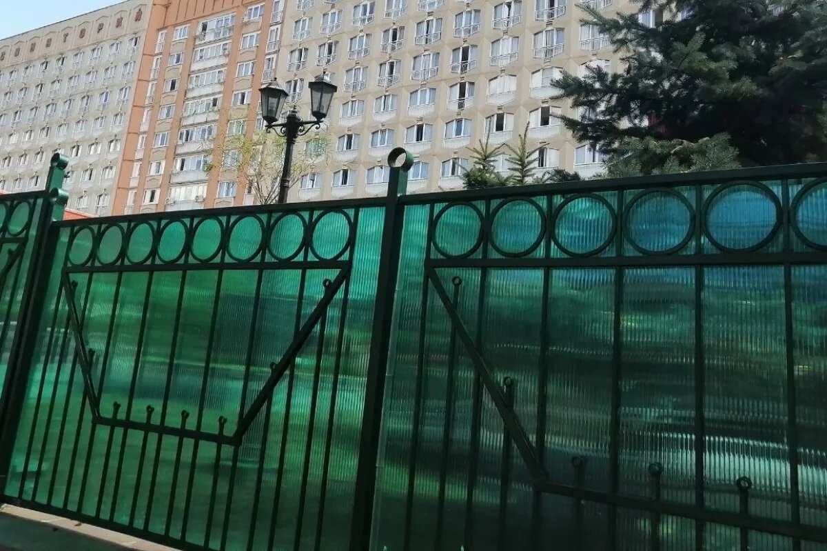    Здание здравницы окружает высокий забор.