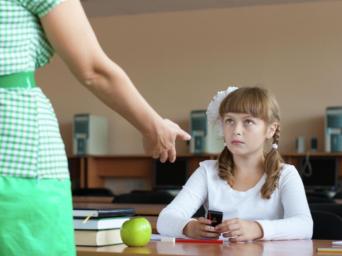    Учитель забирает мобильный телефон на уроке© Depositphotos.com / Andrey_Kuzmin