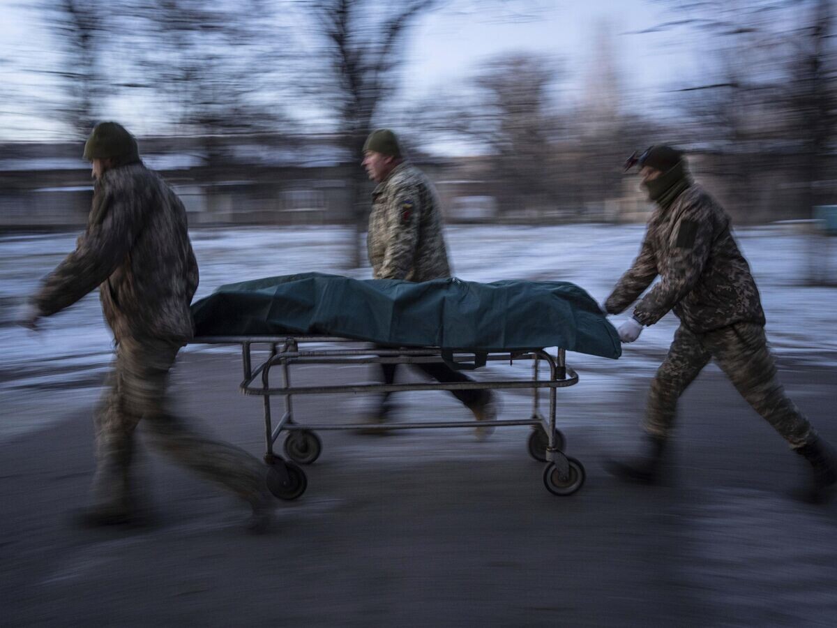    Украинские военнослужащие перевозят носилки с погибшим в Донецкой области© AP Photo / Evgeniy Maloletka