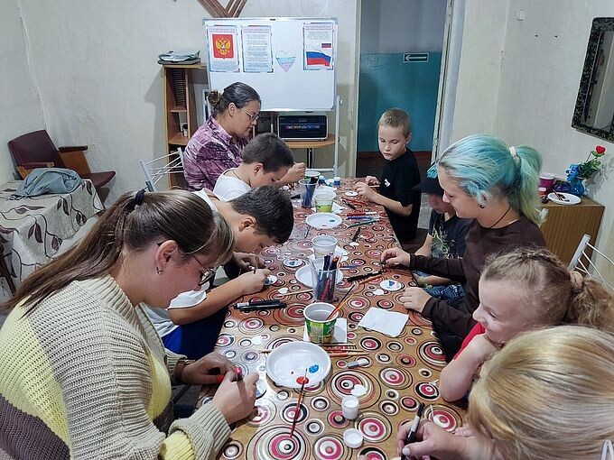 Дети и взрослые заняты раскрашиванием магнитов
