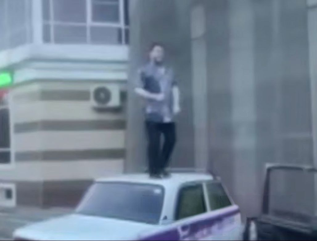 Мигрант устроил танцы на крыше чужого автомобиля. Фото: скриншот "Многонационал"