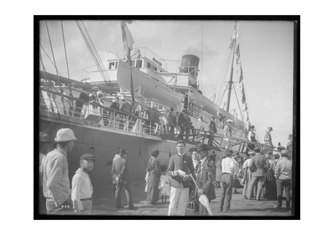 Гавайи уже тогда были популярным направлением для американской элиты. На этом фото пассажиры парохода Ohio прибывают в Гонолулу, а на пристани их встречает мужчина в костюме, с гирляндой леи на шее и зонтиком в руках.