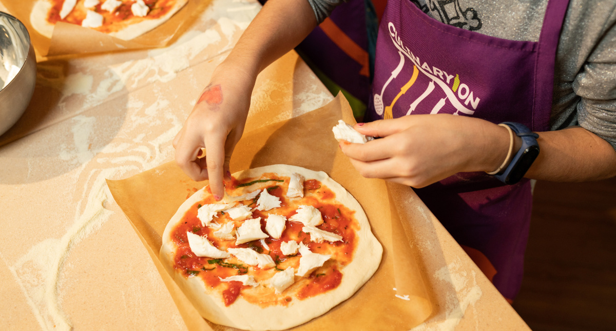 Шеф-повар рассказывает секреты идеальной пиццы на кулинарном мастер классе.