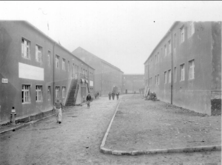 Освобождённые заключённые на лагерной улице между блоками 45 (слева) и 40. На заднем плане видно здание лагерного вещевого склада.