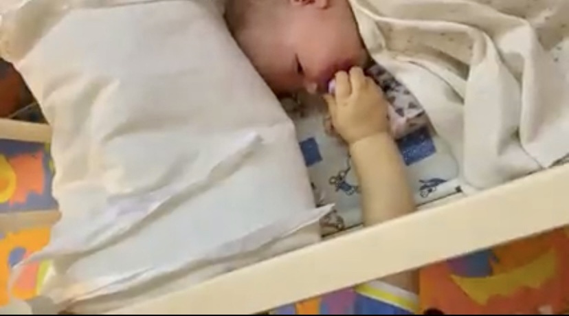 Дает ему соску.