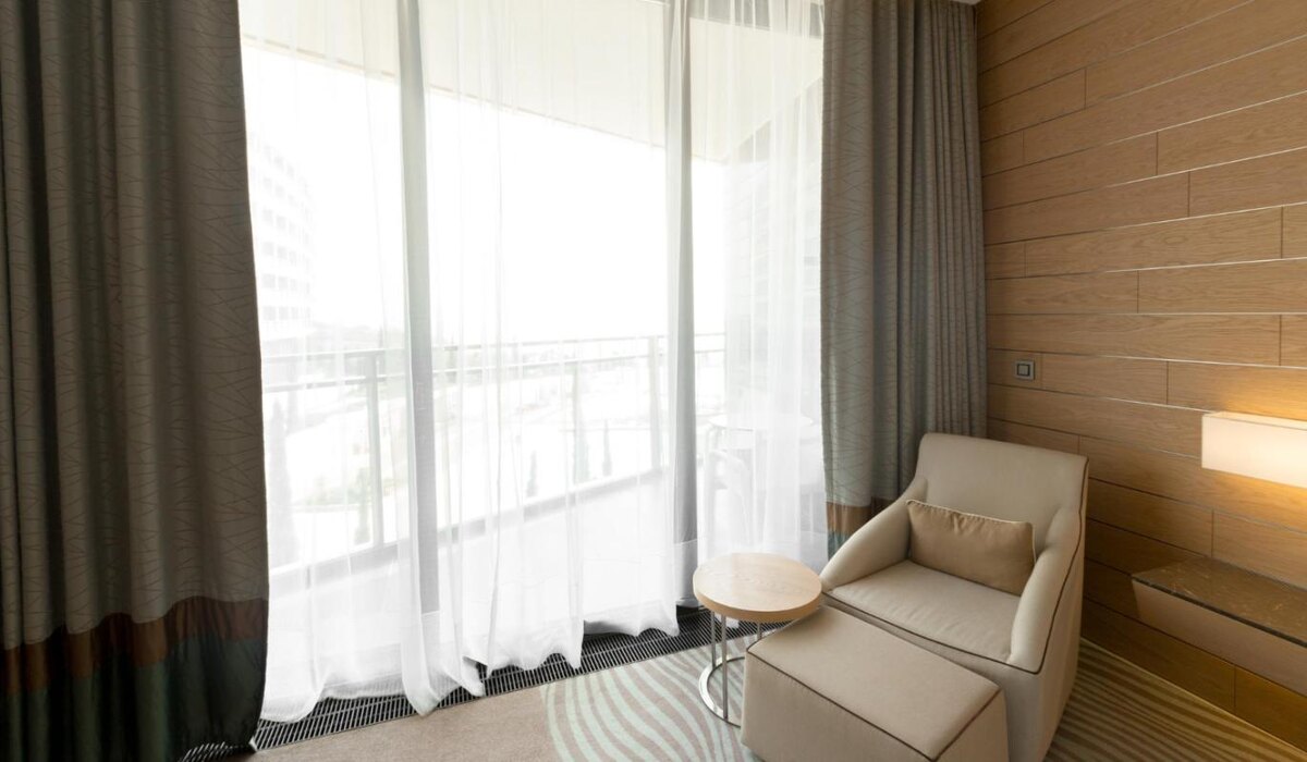     Интерьер с панорамными окнами – текстиль, умные жалюзи и цветовые акценты