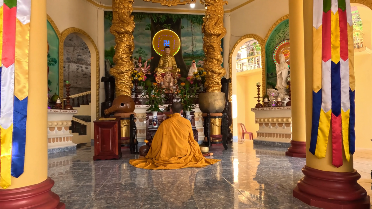 Монах молится и бьёт в гонг