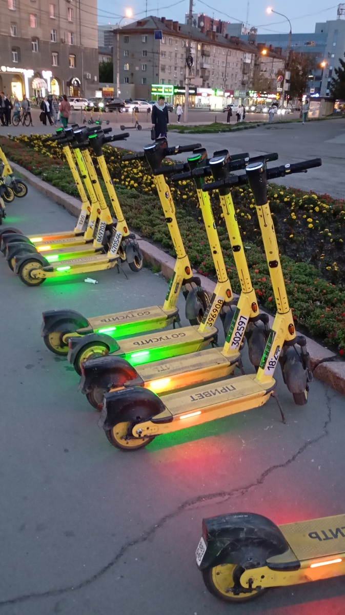 Самокаты на парковке. Стоят ровно. Расстановку осуществляет специально обученные люди.
