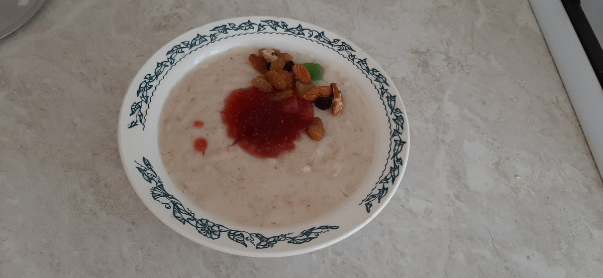 Овсянка с малиновым вареньем, орехами, сухофруктами и цукатами на съемной квартире. Иногда мед добавляем)