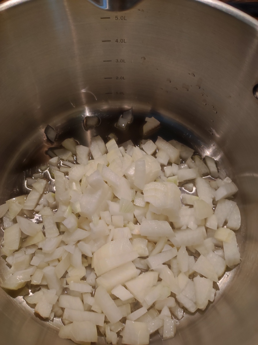 В кастрюле с толстым дном разогреваем растительное масло и добавляем нарезанный кубиком лук. Слегка обжариваем, до прозрачности