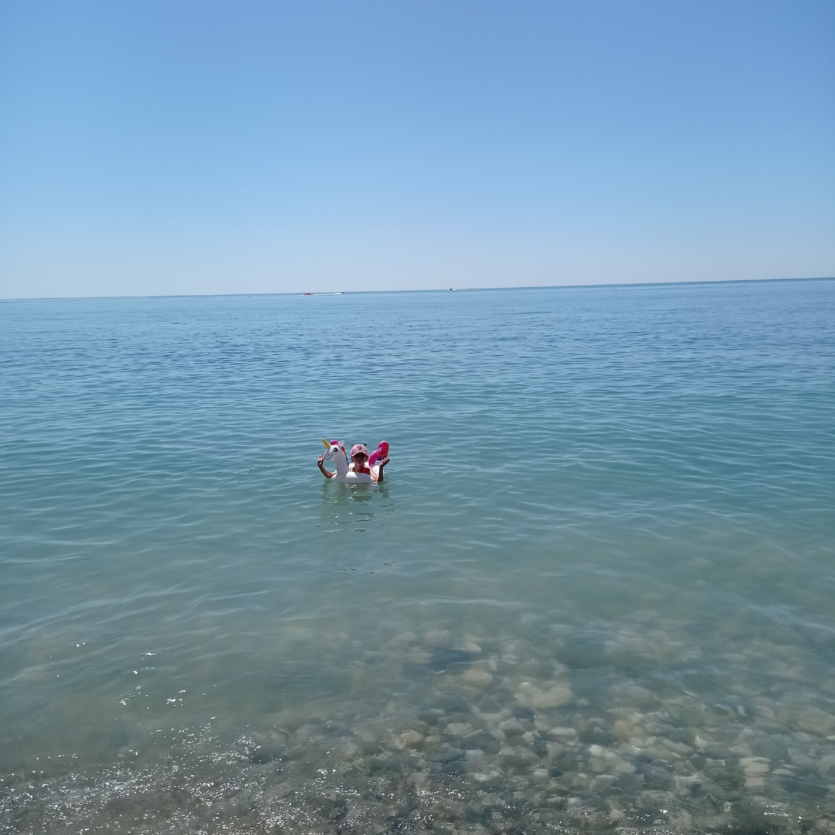 Дочка плавает в кругу в Черном море в Абхазии