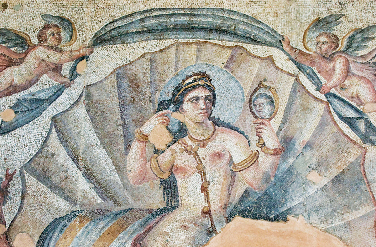 Венера в ее туалете
Эта римская мозаика, изображающая Венеру за туалетом, является ярким примером того, как мозаичное искусство превосходит настенную живопись в богатстве цветовой гаммы. В частности, здесь можно увидеть более насыщенные и нежные оттенки синего, зеленого, серого и розового. Мозаика является частью серии, в которую также входят изображения купающейся Артемиды и Тетис, богини моря, в окружении морских существ.
Мозаика (деталь), третий век. Музей Ас-Сувайда (здание муниципалитета), Ас-Сувайда (Сирия).