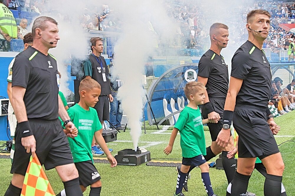 Все как обычно, бригада судей и стартовые составы команд выходят на поле стадиона в сопровождении детей.