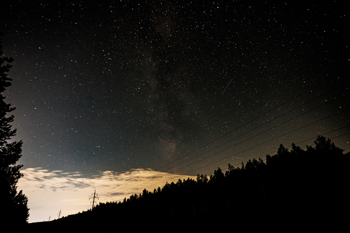 Млечный путь и надвигающееся облако, которое отражает городскую засветку...