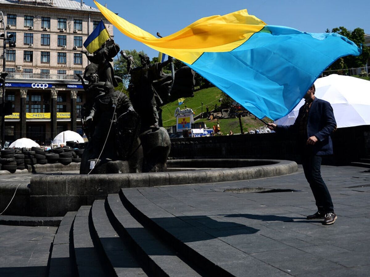    Мужчина с украинским флагом у памятника основателям Киева на площади Независимости© РИА Новости / Алексей Филиппов