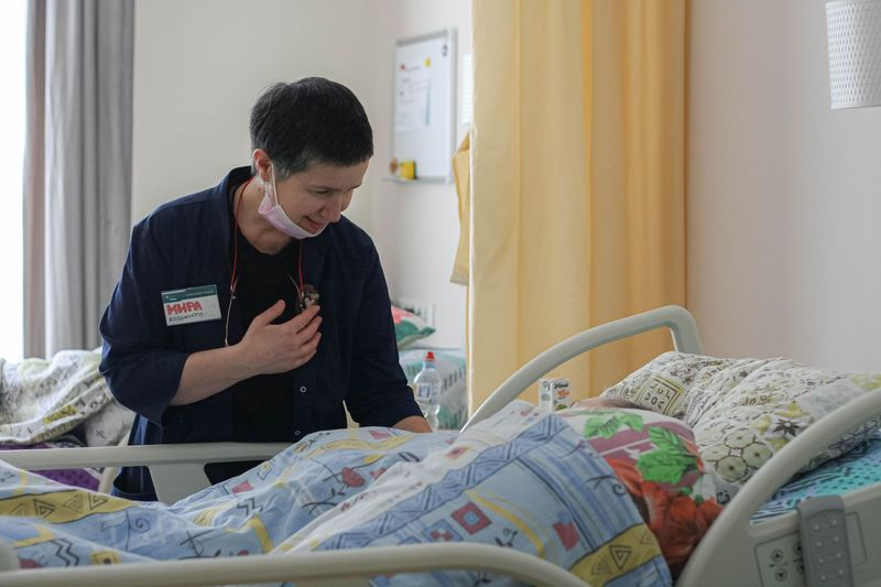 Мира Тристан у постели пациента. Фото из архива фонда «Вера»