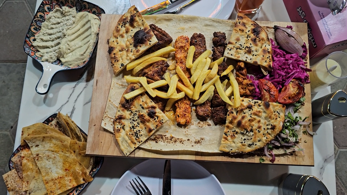 Порция гриля на двоих - микс из курицы, говядины и баранины. Всё что на фото (включая закуски и хлеб) - 11 долларов.