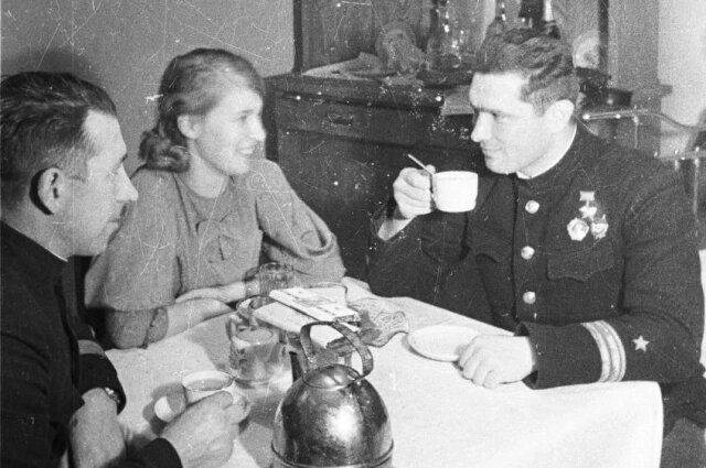    Герой Советского Союза летчик-истребитель Б.Ф. Сафонов со своей женой Евгенией и комиссаром авиаполка П. Редьковым за чаепитием. Фотография сделана в квартире Б.Ф. Сафонова в Ваенге (сейчас город Североморск). Фото: Из архива/ Евгений Халдей