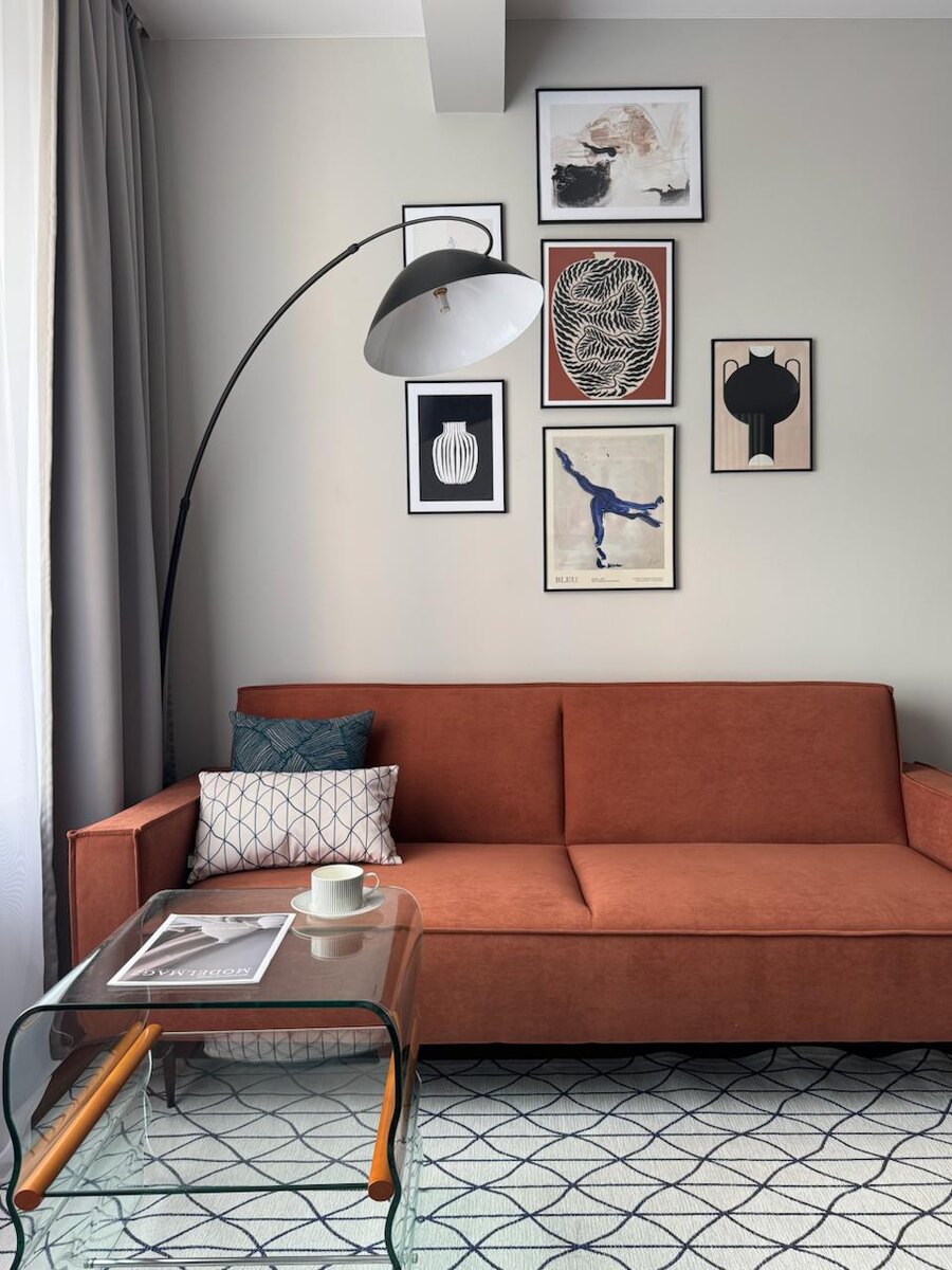 Гостиная с терракотовым диваном в ЖК Родной город. Постреы на стенах - с маркетплейсов.