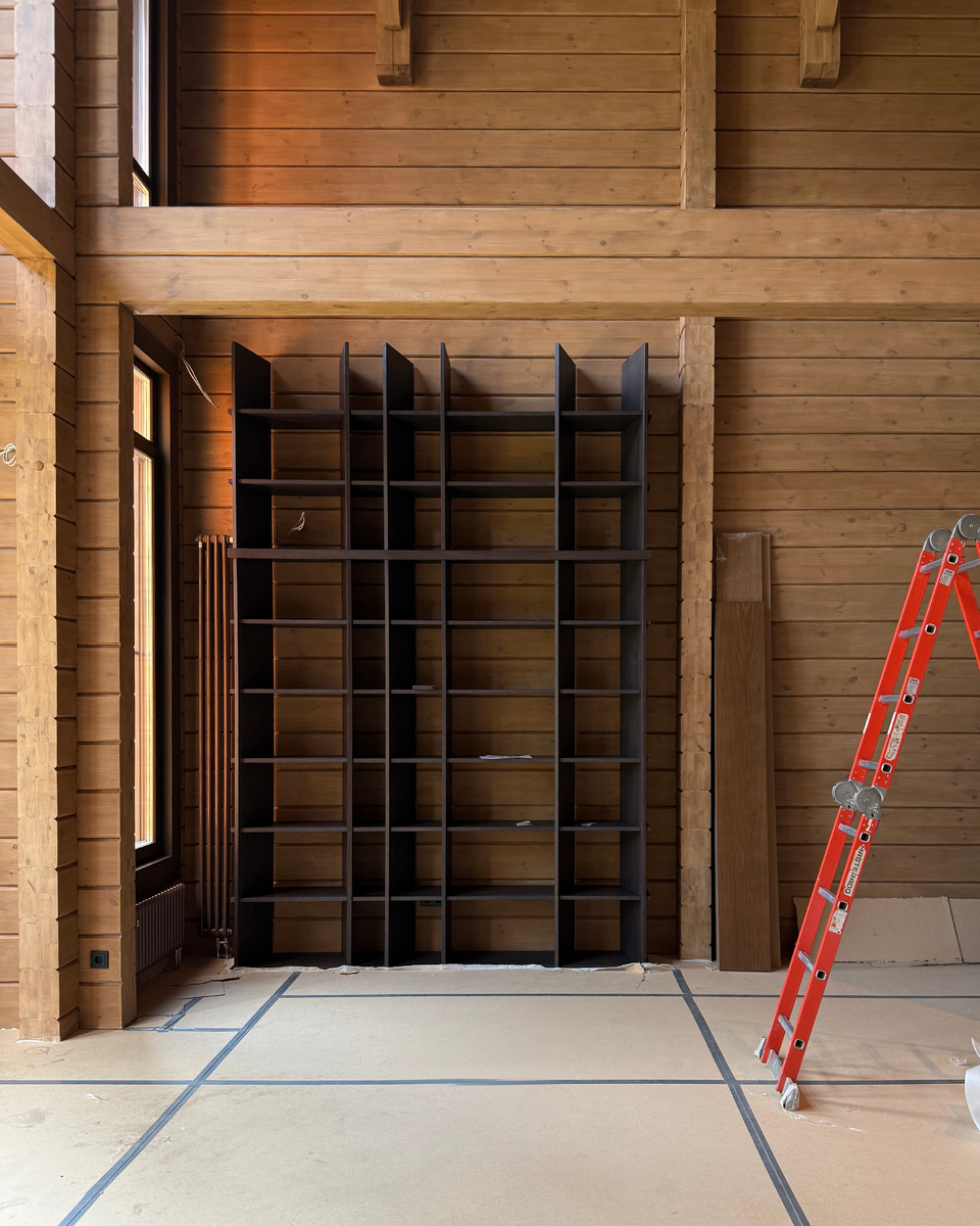 Стеллаж - библиотека в двухсветной гостиной деревянного дома