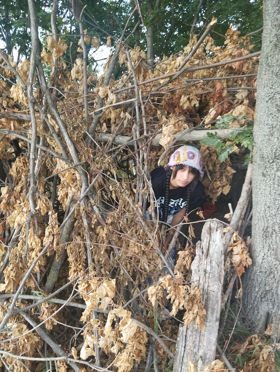 Дочка смотрит в окно из шалаша. Вид как раз на поле подсолнухов и гору Джуца