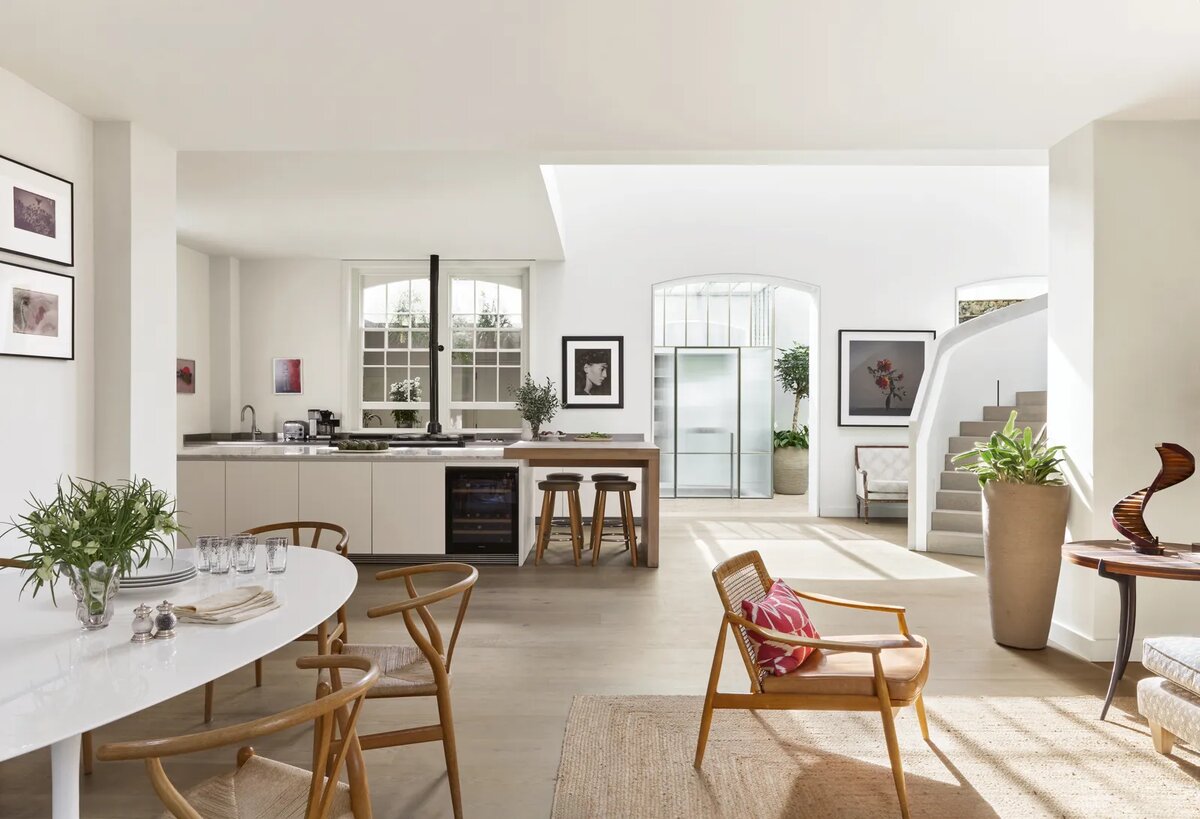 В пространстве открытой планировки доминирует лестница – деревянная конструкция, покрытая глиняной штукатуркой. За ней находится кабинет с палисандровым столом 1960 года работы Йоргена Педерсена для E Pederson & Son и стеной книжных полок. В зоне отдыха полки заставлены небольшими фотографиями таких художников, как Васанта Йоганантхан, Сёмей Томацу, Брюс Дэвидсон и Гвидо Гвиди.