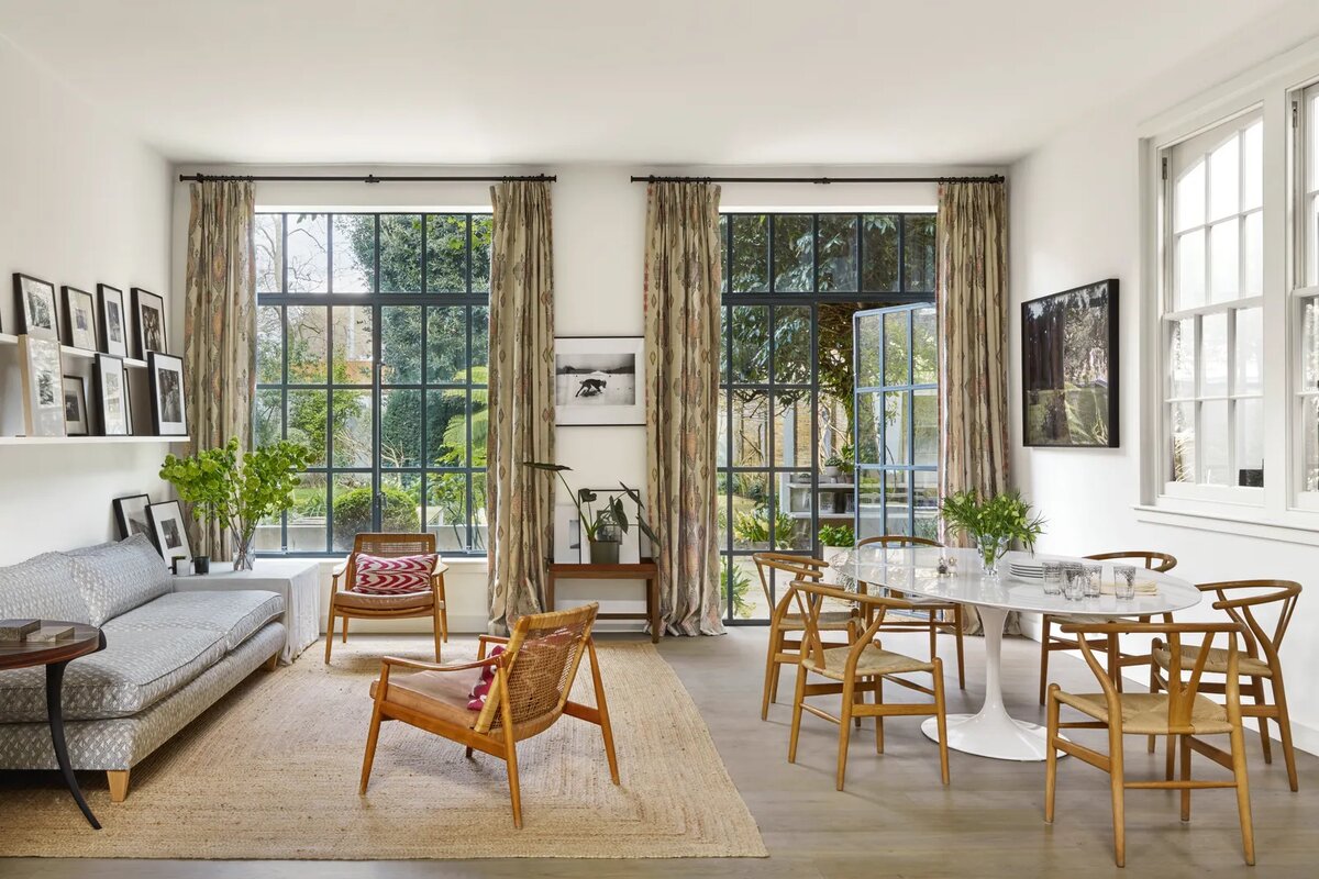 В зоне отдыха и столовой шторы из ткани Travelling Light от Кита Кемпа, диван George Smith, обитый тканью Belge (обе ткани от Christopher Farr Cloth), и подушки Yastik от Rifat Ozbek добавляют узор и цвет деревянным стульям и джутовому ковру от La Redoute.
