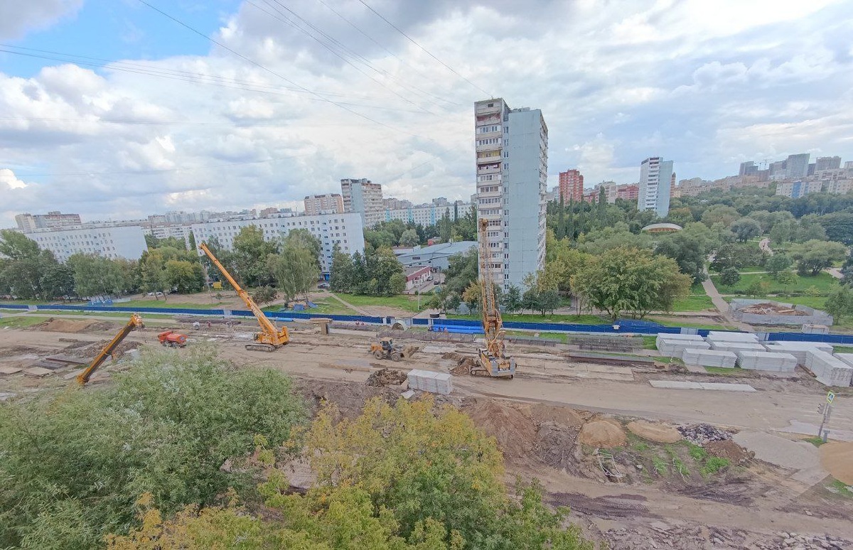 📷 1.1: Общий вид коридора работ. Видны каркас демонтажной камеры, автокраны, буровая техника и склад ЖБ-элементов.