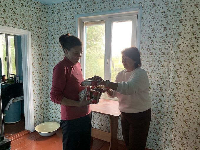 Шуйская Ольга Петровна вручает женщине продуктовый набор