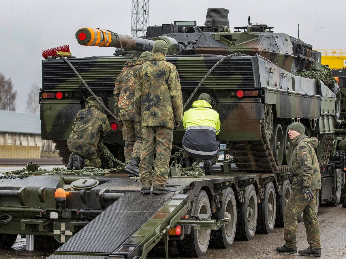    Немецкие военнослужащие загружают танк Leopard 2 на железнодорожной станции© AP Photo / Mindaugas Kulbis