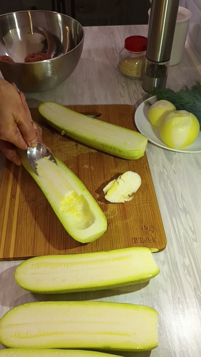 Приготовление:
1. Тщательно вымойте кабачки. Разрежьте их вдоль на две части.
Аккуратно выньте мякоть, оставляя стенки толщиной 8-10 мм. Мякоть нарежьте мелкими кубиками.