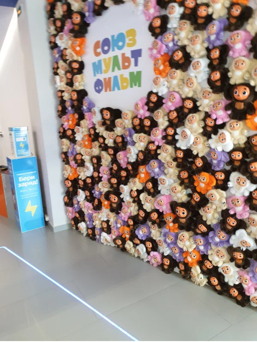 Стена из маленьких чебурашек на входе 