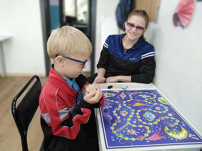 Мальчик с мамой играют в настольную игру