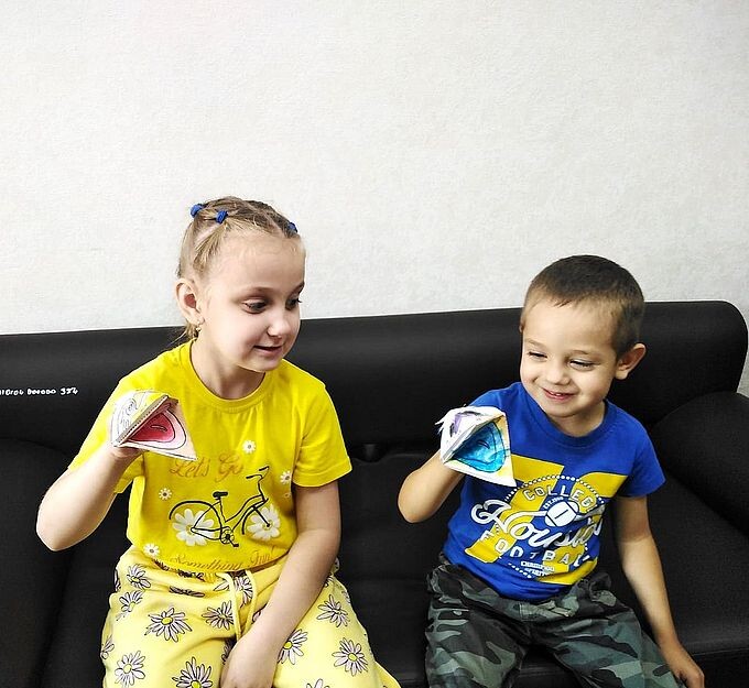 Девочка и мальчик с оригами головы змеи на руках