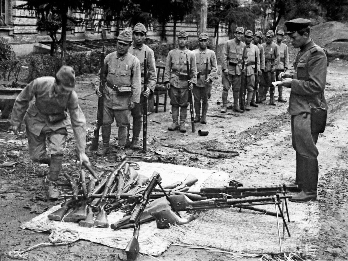    Японские солдаты капитулирующей 16 августа 1945 года Квантунской армии сдают свое оружие советскому офицеру© РИА Новости / Евгений Халдей