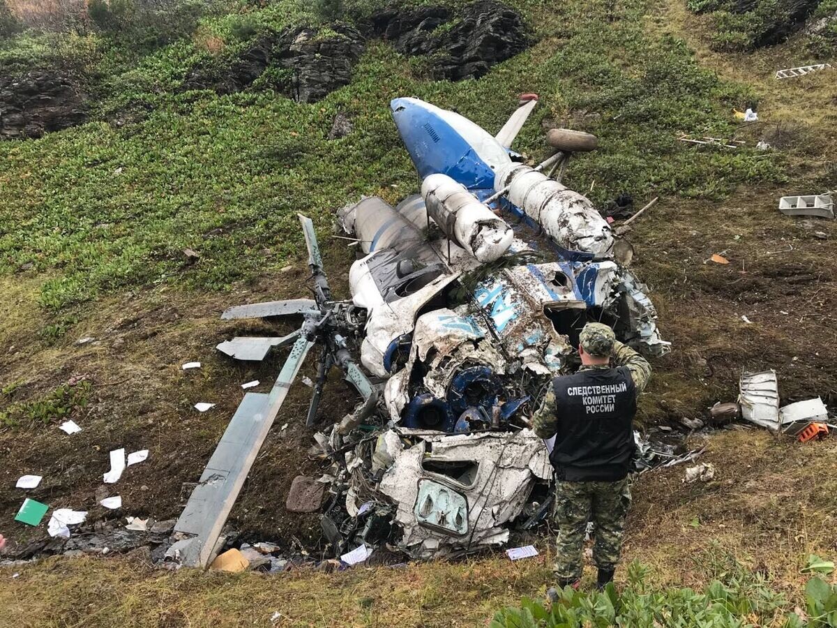    Сотрудник СК РФ осматривает обломки вертолета Ми-8 авиакомпании "Ангара", потерпевшего крушение в Казачинско-Ленском районе Иркутской области© Фото : СК РФ