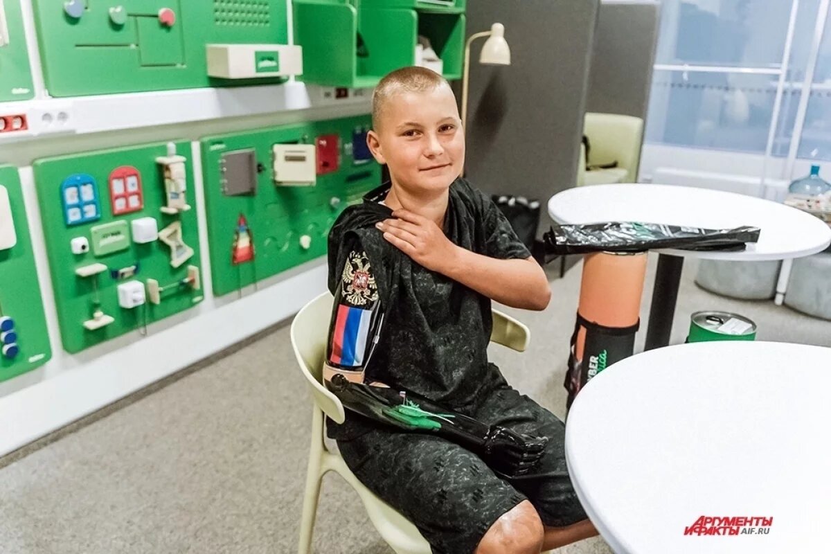    Его киберрука чёрного цвета, с зеленоватым отливом, а на предплечье — российский герб и триколор (мальчишка сам выбирал дизайн).