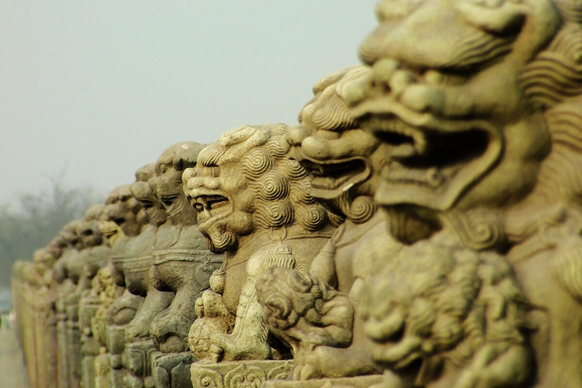 Львы в ряд на средневековом мосту Лугоу («мост Марко Поло»), Пекин. 