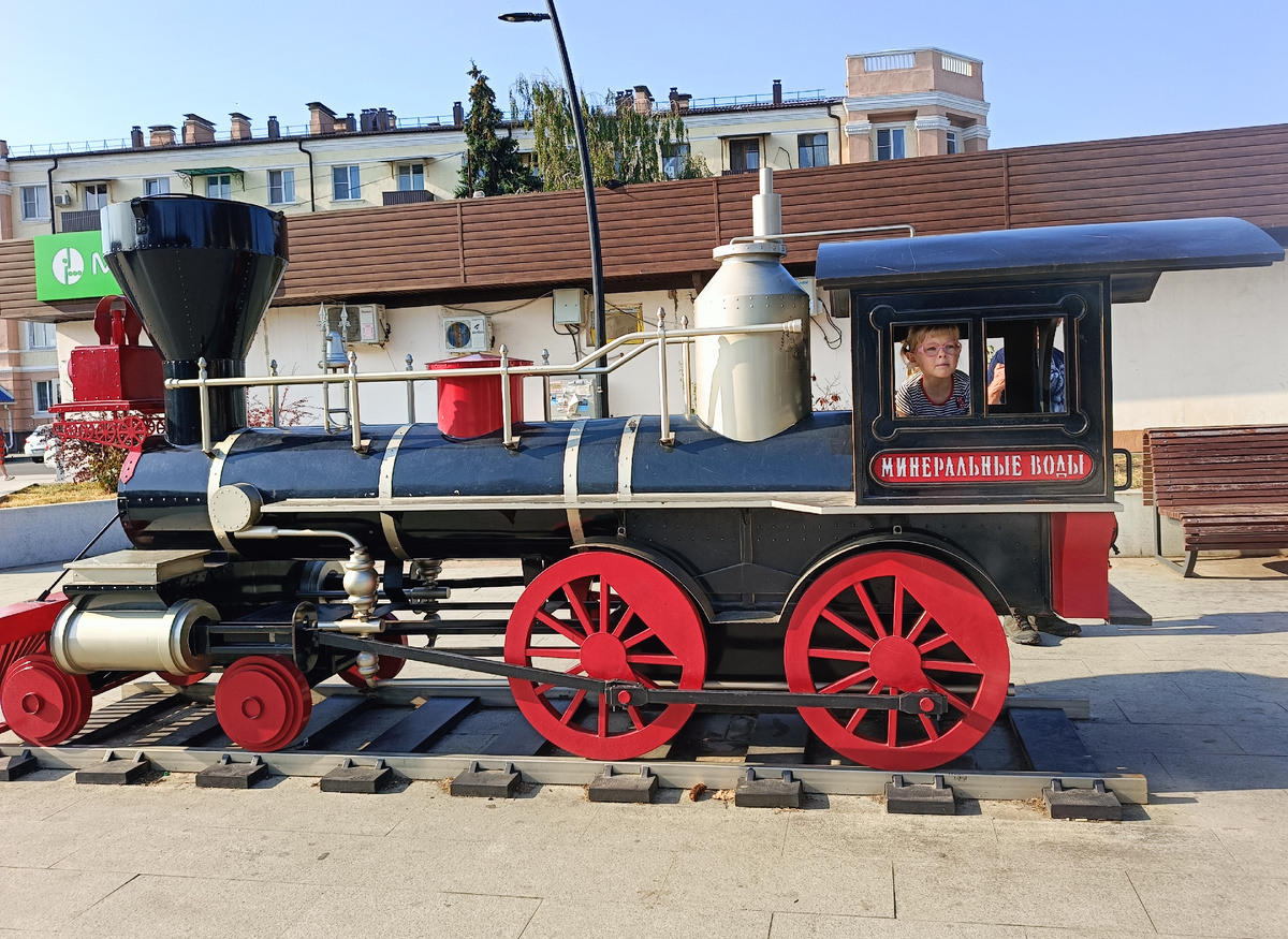 Просто милый игрушечный паровозик рядом с вокзалом в Минводах