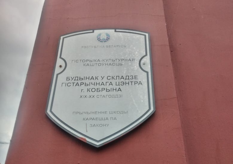 " Историко-культурная ценность. Здание в составе исторического центра г.  Кобрина 19-20 века. Нанесение  ущерба наказывается по закону. " Такие таблички висят почти на всех домах в центре города. Надпись на белорусском языке. 