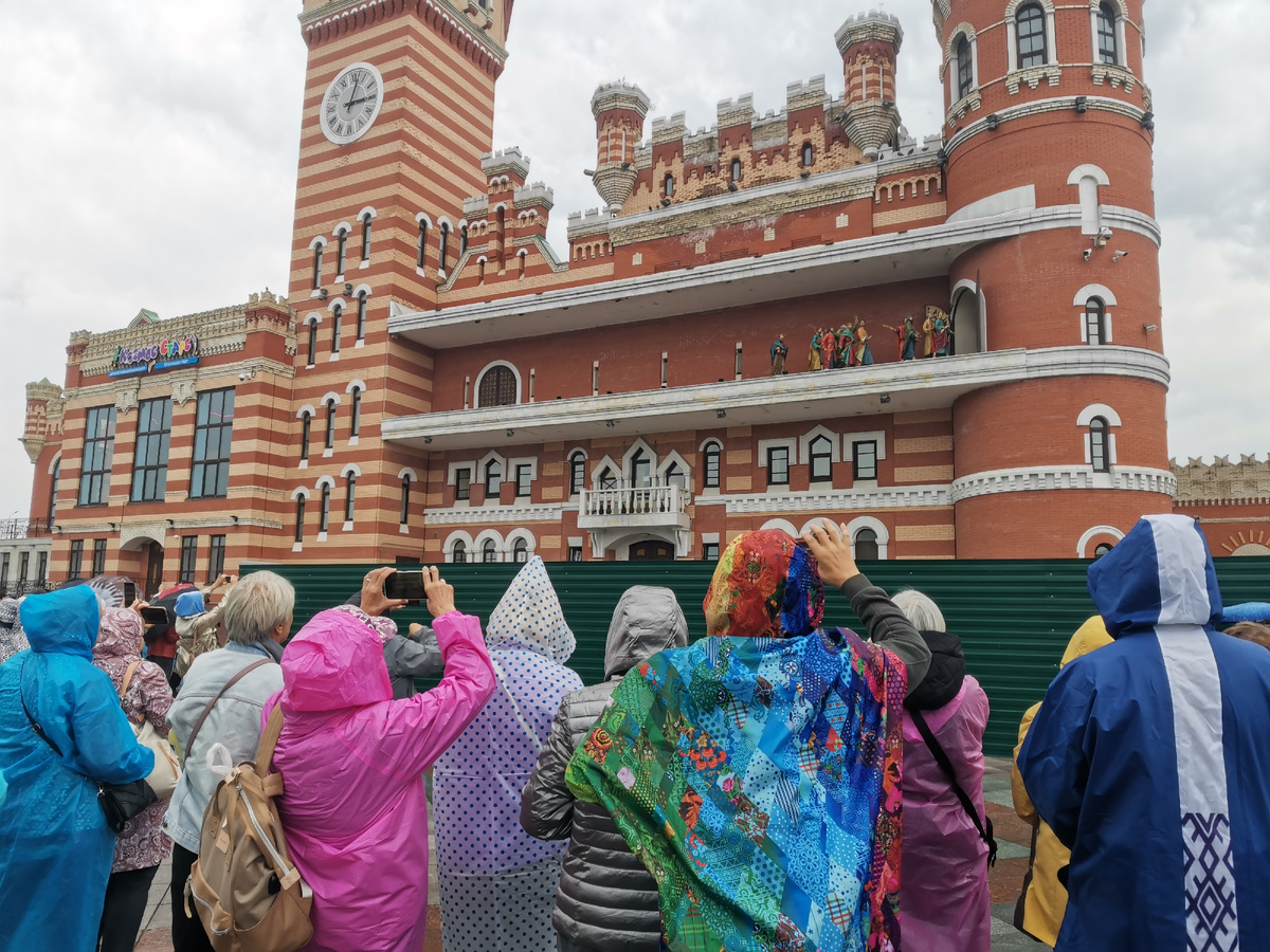 Группа уфимских туристов безотрывно следит за процессией на башне