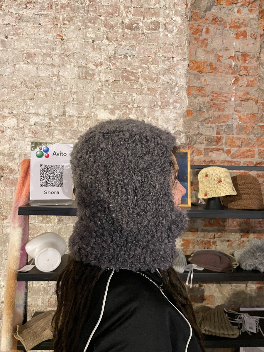 Девушка примеряет балаклаву на дреды. А на полках  мои остатки 1-го дня