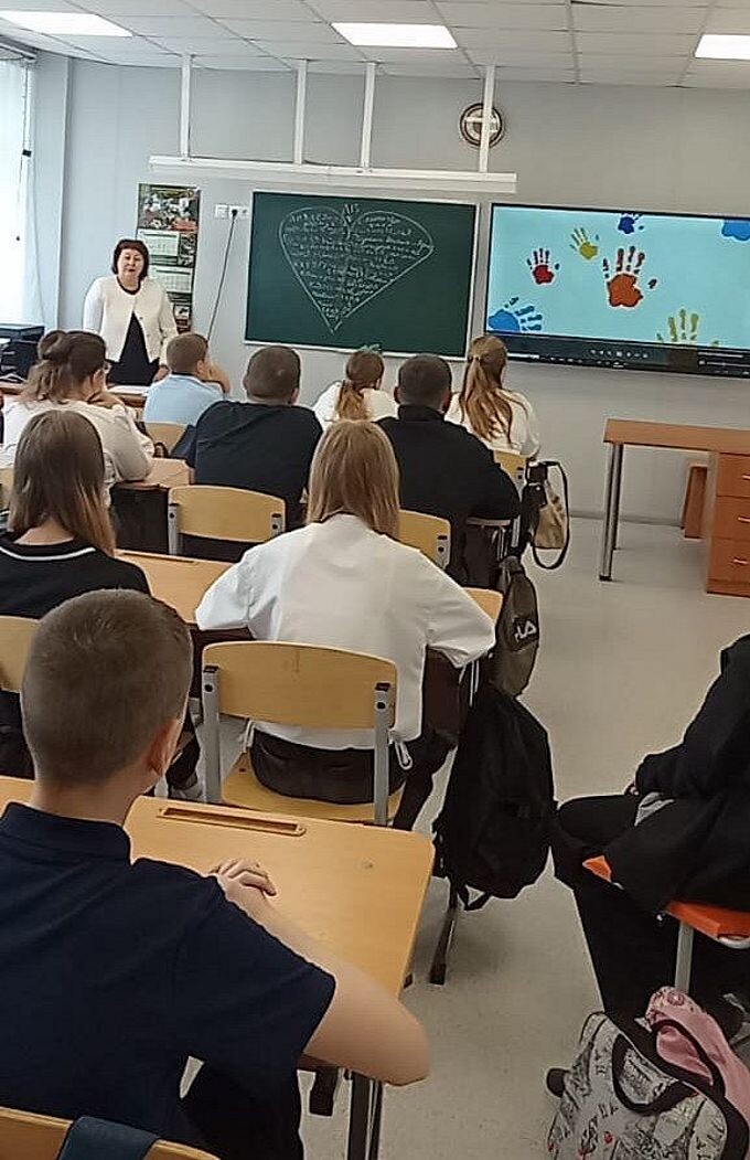 Ученики смотрят фильм на большом экране телевизора