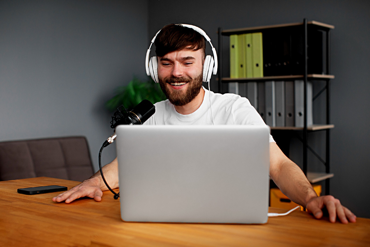 Человек за ноутбуком с наушниками