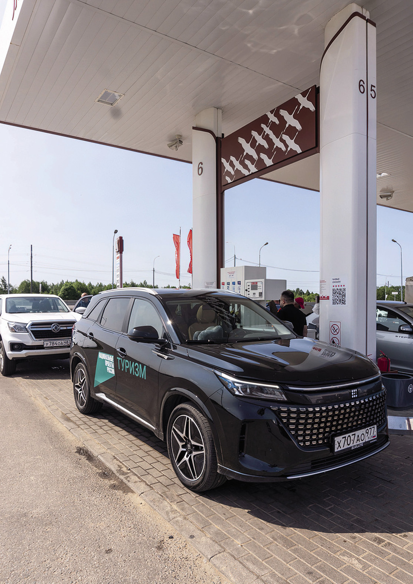 Автотур проходил на кроссоверах Evolute i-SPACE. По силуэтам парящих лебедей можно понять, что эта заправка «Лукойла» находится рядом с Ржевским мемориалом.