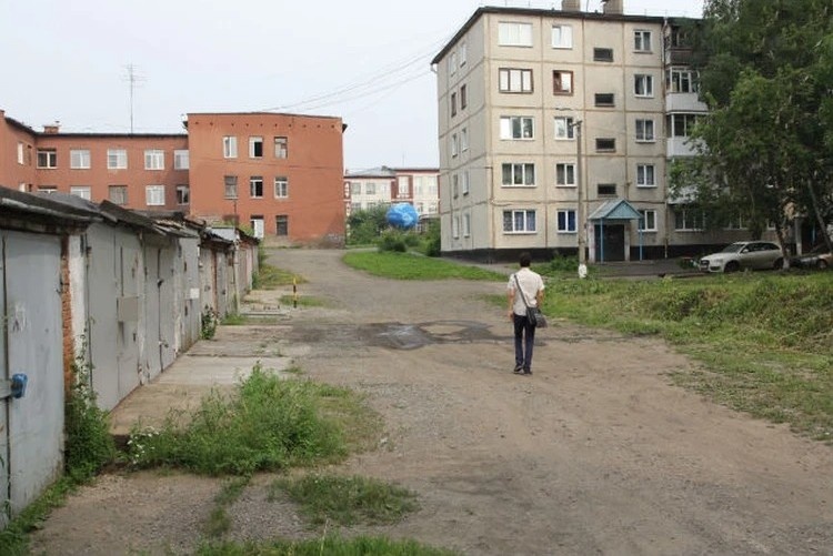 Фотография дома бабушки (слева: красное, кирпичное здание) и домой семьи (справа) - место исчезновения девушки