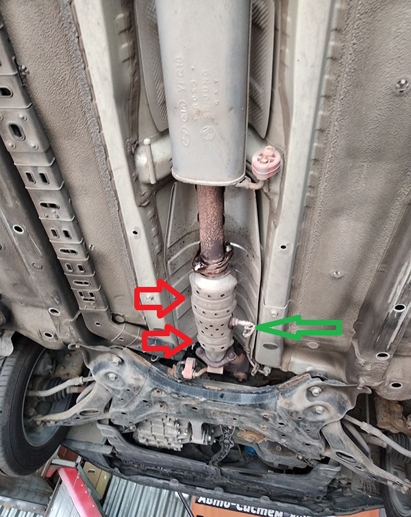 Единственный в случае Киа Оптима 3 с мотором G4KD (150 л.с.) катализатор находится под днищем (показан красными стрелками). Зеленой стрелкой указан торчащий из корпуса катализатора задний лямбда-зонд.