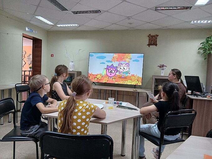 Дети смотрят мультфильм на большом экране