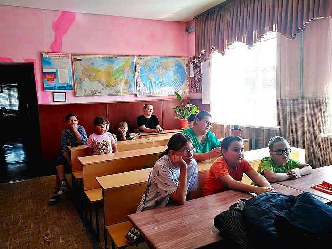 Дети и взрослые слушают рассказ об организации работы пожарно-спасательной части